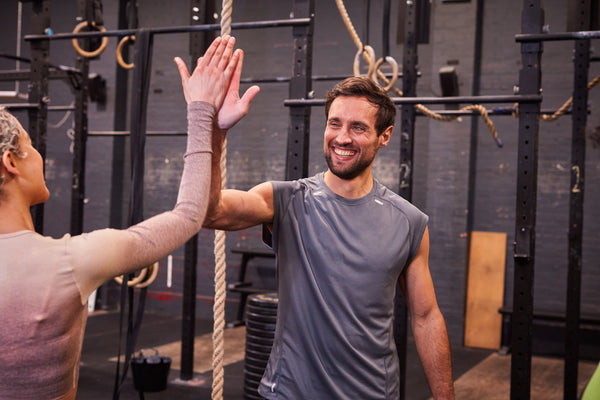 Man and woman celebrating in gym